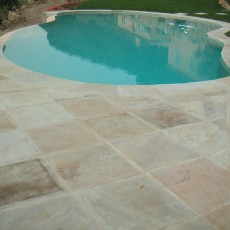 Natuursteen terrastegels beige naast zwembad buiten