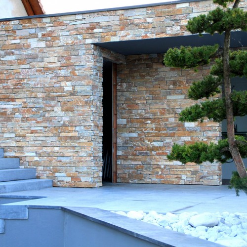 Wand ingang huis met meerkleurige natuursteenstrips