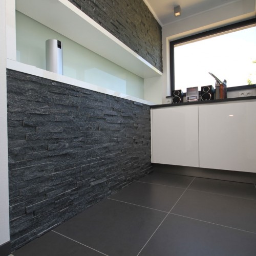 Wand van keukenplatform met natuursteenstrips met zwarte