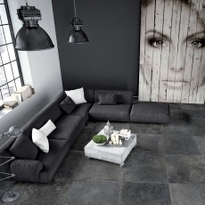 Moderne zwarte sofa op keramische tegels natuursteen look
