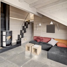 Moderne living met kachel op grijze keramische tegels natuursteen look
