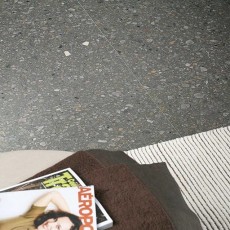 Stoel en magazine op grijze terrazzo keramische tegels