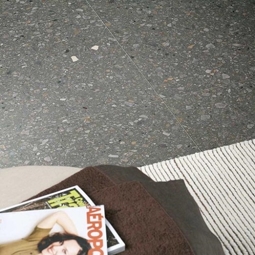 Stoel en magazine op grijze terrazzo keramische tegels